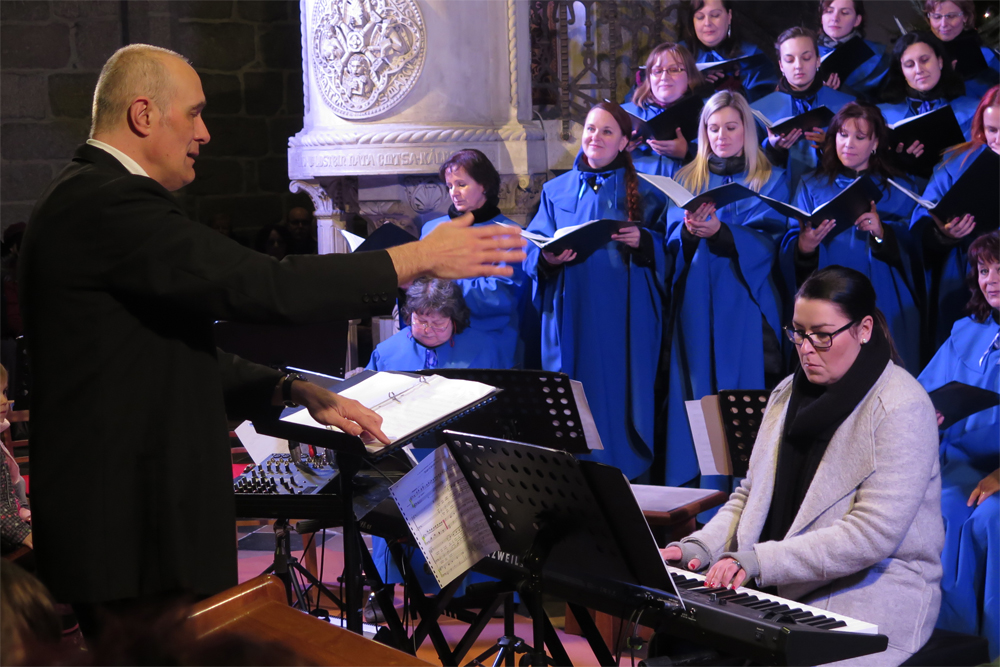 Dirigent Karel Tomek, u kláves Anička Kolaříková a za nimi část sboru Musica Animata.