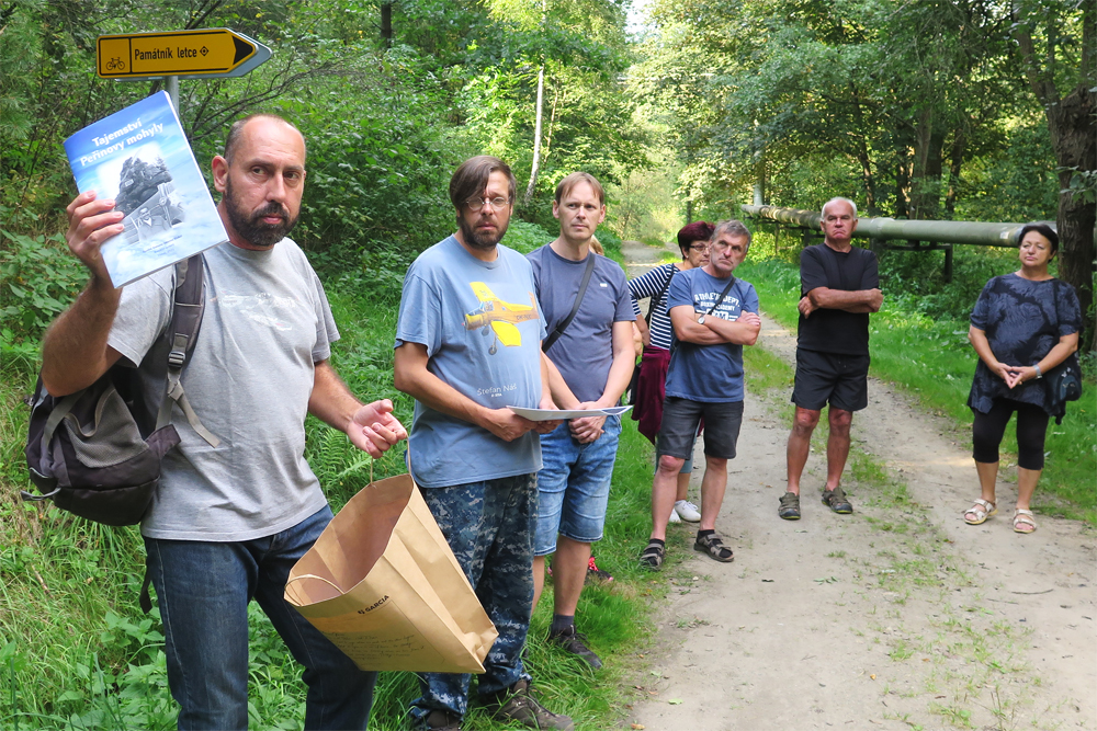 Jaroslav Bašta ukazuje sborník Tajemství Peřinovy mohyly, který vychází k 90. výročí tragédie v Lorenzových sadech. Za ním stojí další členové Spolku historie letectví Třebíč Zdeněk Prukner a Pavel Beroun.